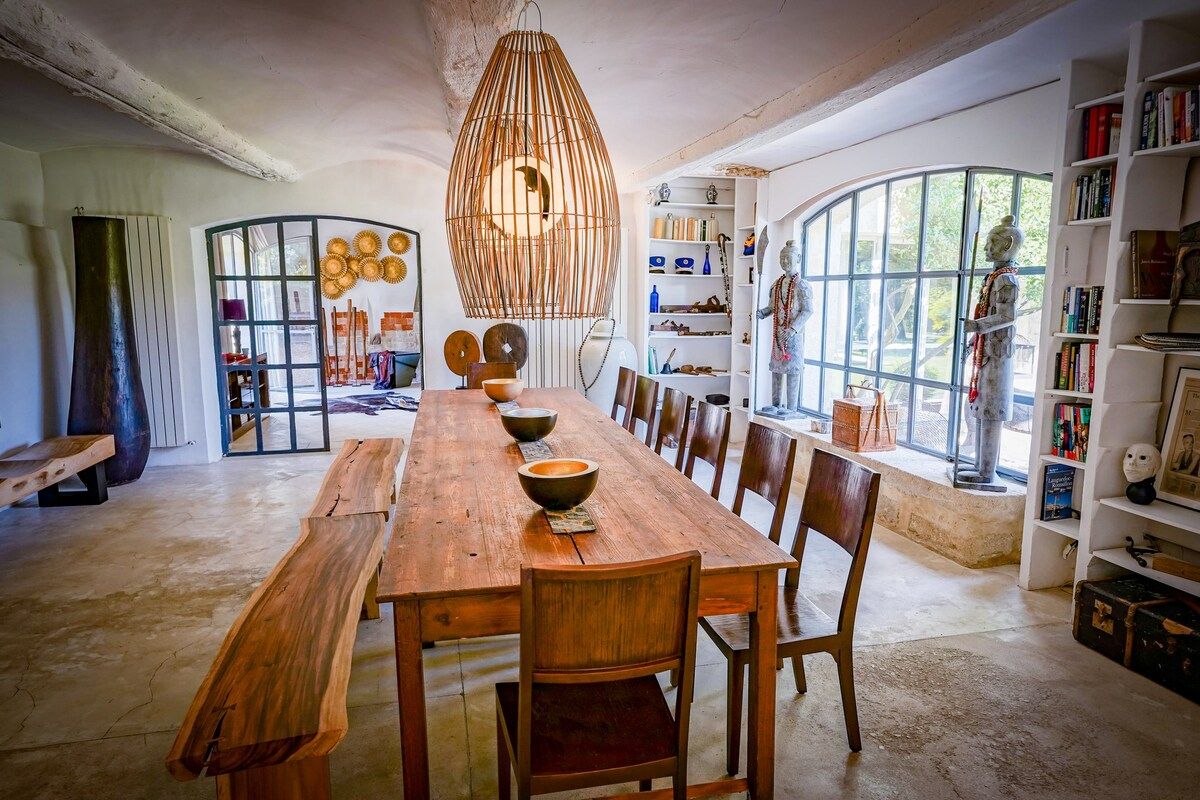 The indoor dining room, a long wooden table beneath woven pendant lights